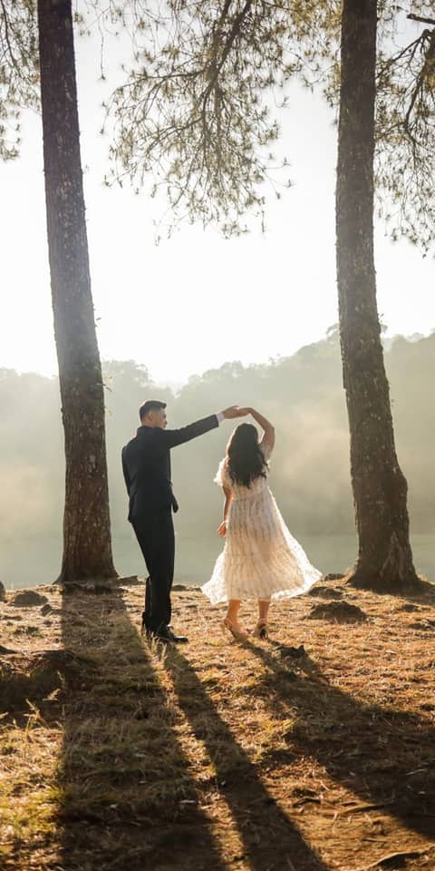 Pasangan berdansa di bawah pohon pinus